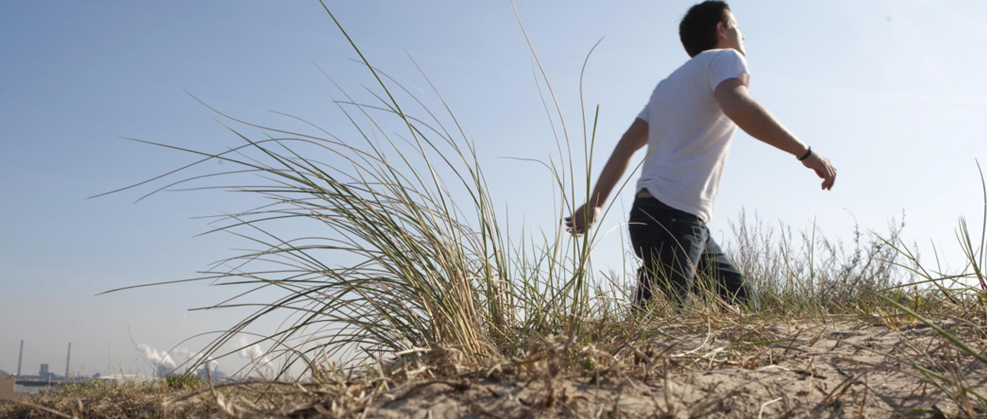 Man walking along sand dune