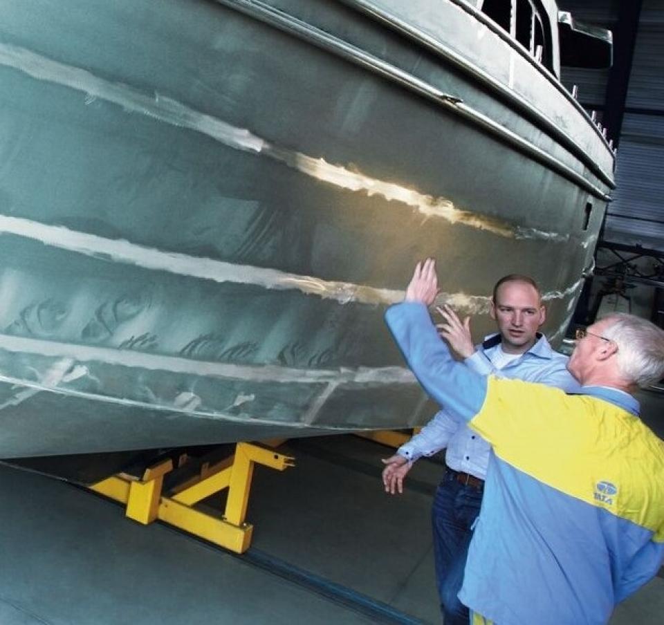 Tata Steel and Linssen workers reviewing the bottom panel of a yacht