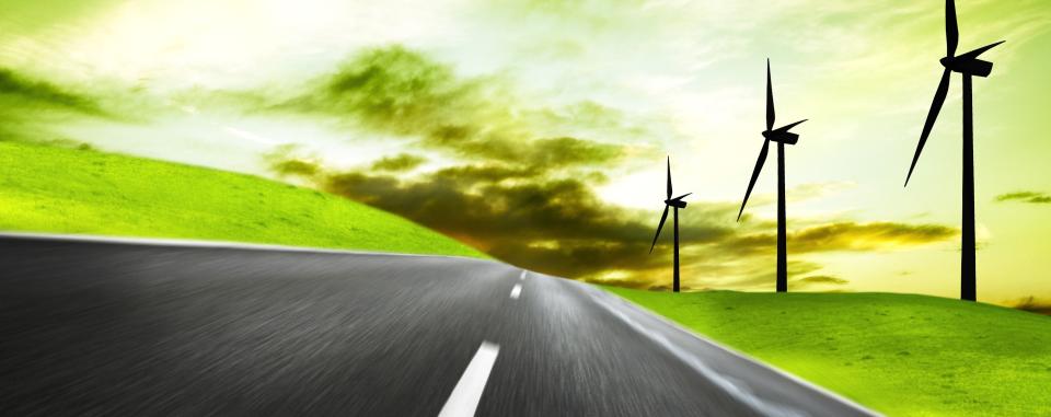 Futuristic picture depicting a road winding the countryside with wind turbines and a green sky