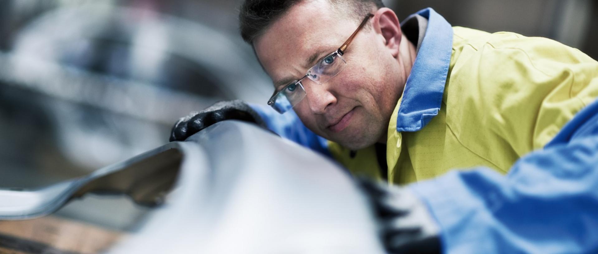 Tata Steel employee studying a piece of metal with a pensive look