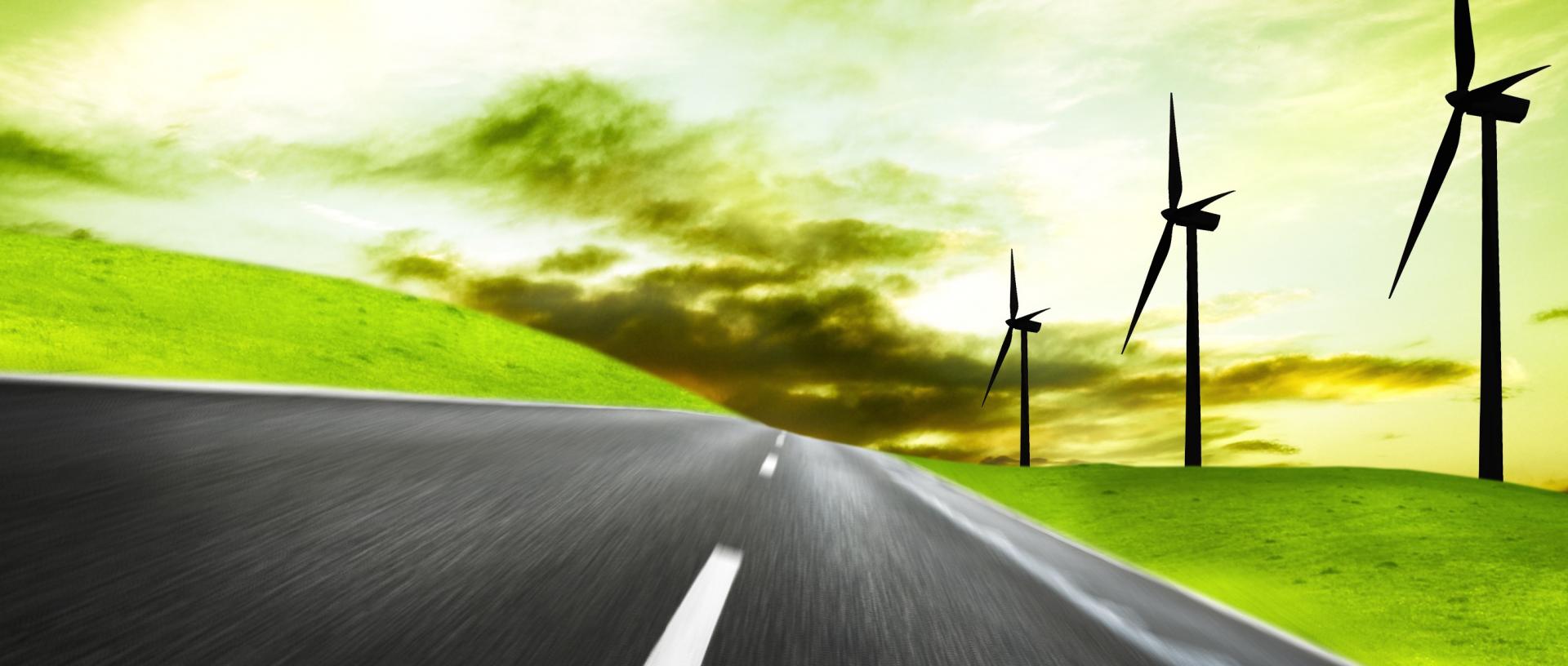 Futuristic picture depicting a road winding the countryside with wind turbines and a green sky