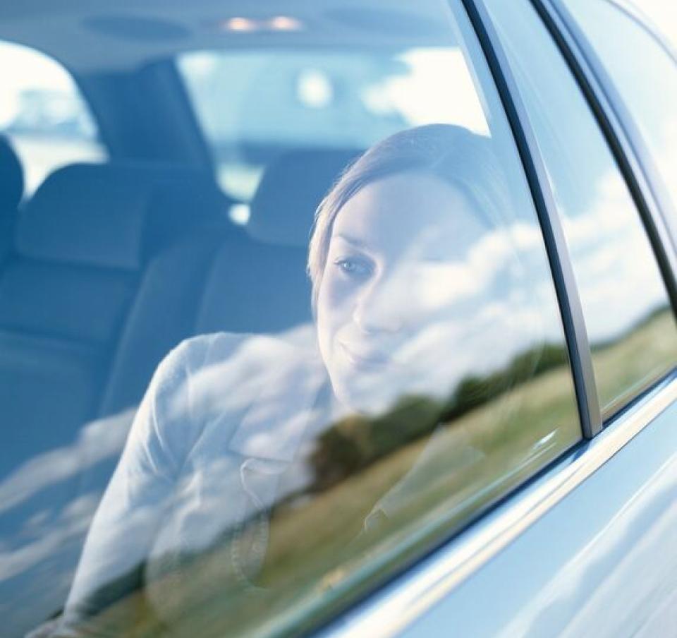 Young woman looking out of car window smiling